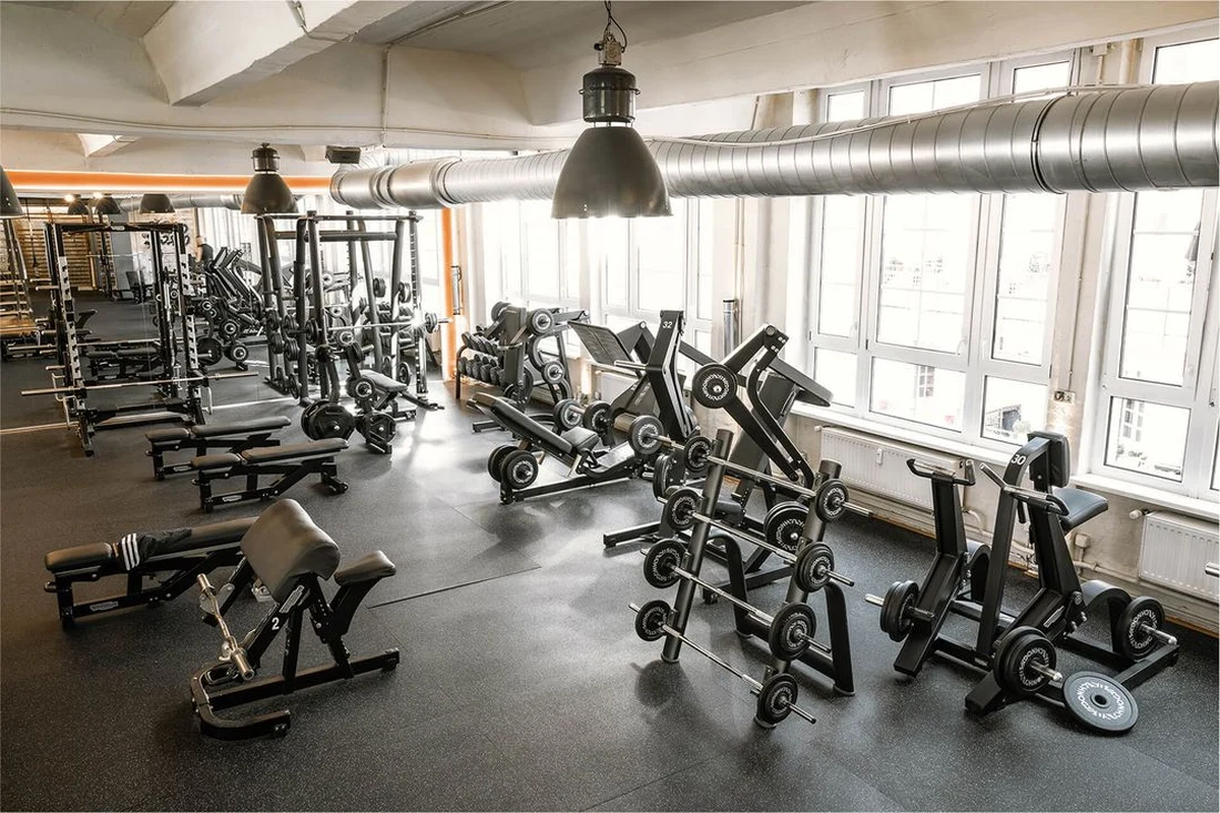 Weitläufiger Trainingsbereich mit Kraftgeräten und Hantelzone im Lokahi Loft Berlin