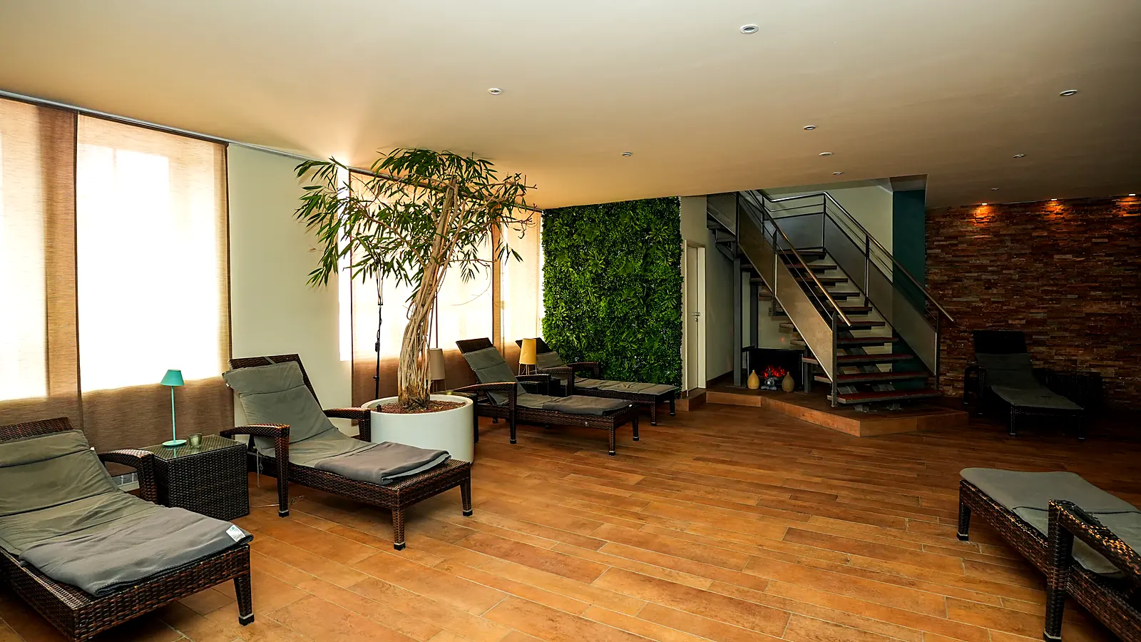 Wellness-Lounge mit Kamin und Rattan-Loungern im Lokahi Loft Berlin